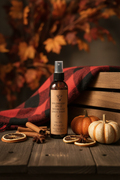 Wildwood Spice Room and Linen Spray on dark wood with cinnamon, star anise, and autumn foliage